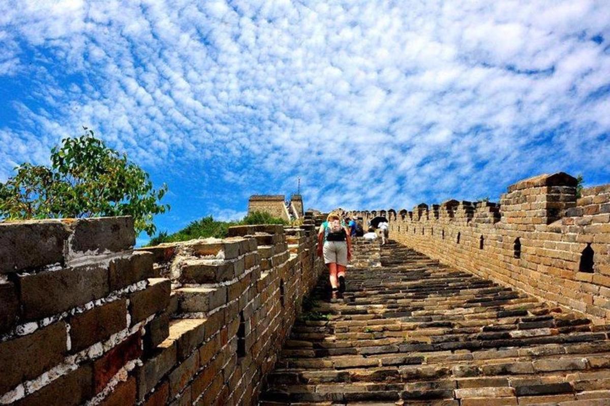 a woman walking up the stairs of the great wall