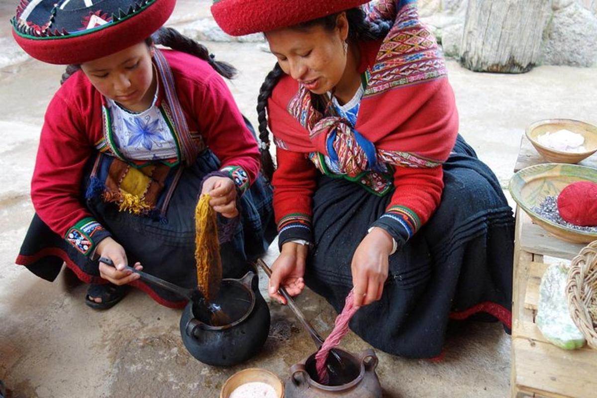 duas mulheres sentadas no chão cozinhando comida em uma panela