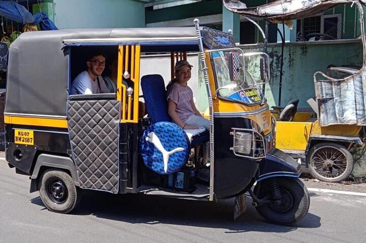 Un hombre y una mujer viajando en un carrito de golf