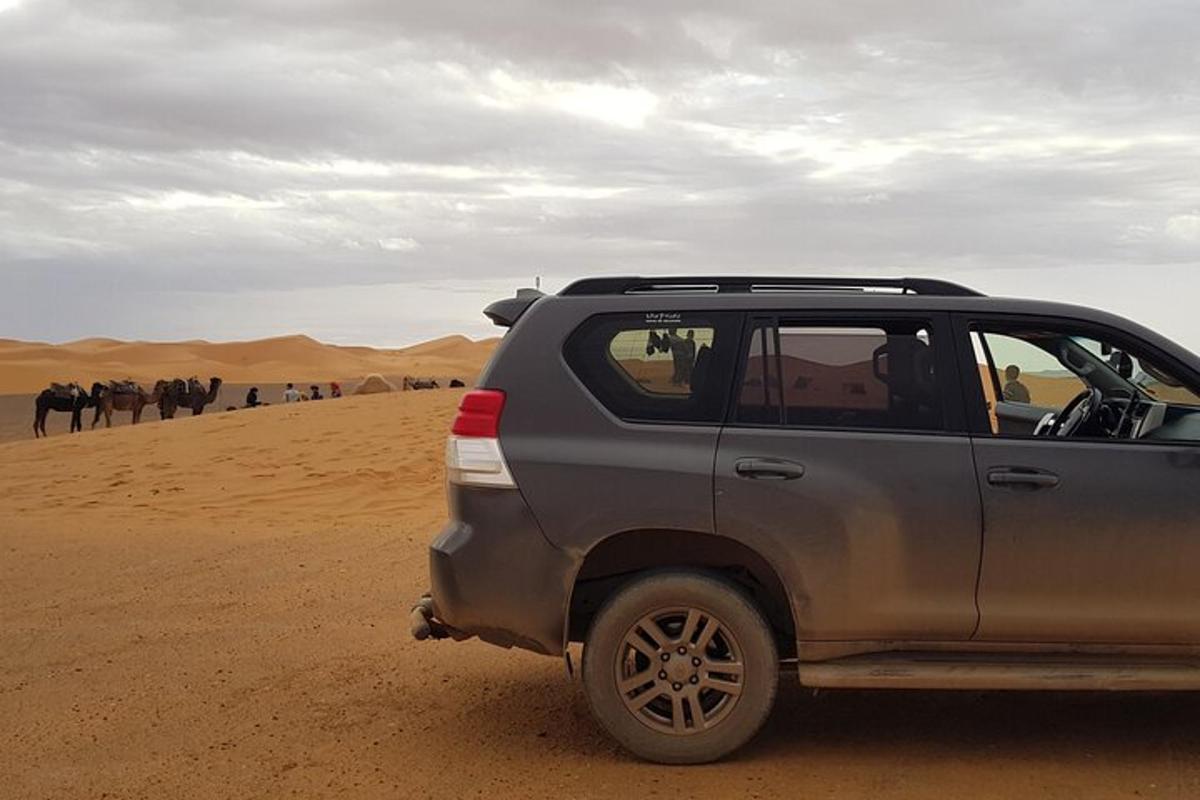 سيارة متوقفة في الصحراء مع مجموعة من الأشخاص