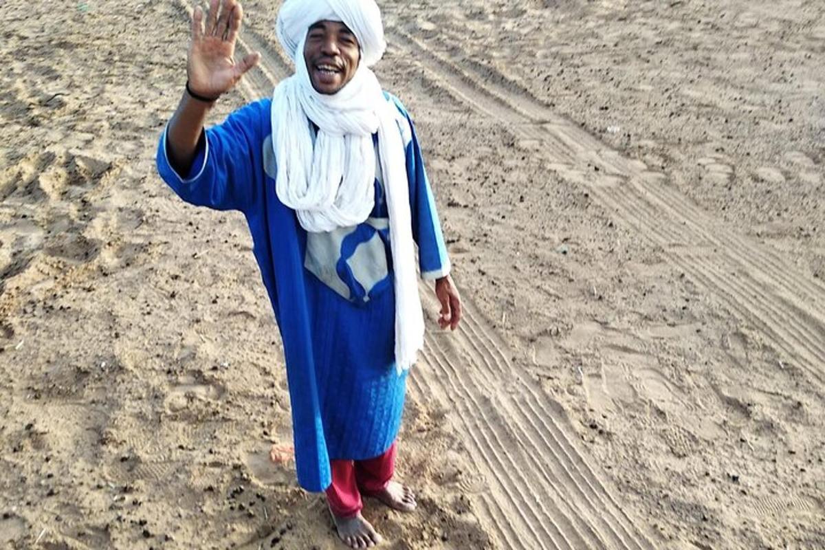 uma mulher está parada na praia com a mão no ar