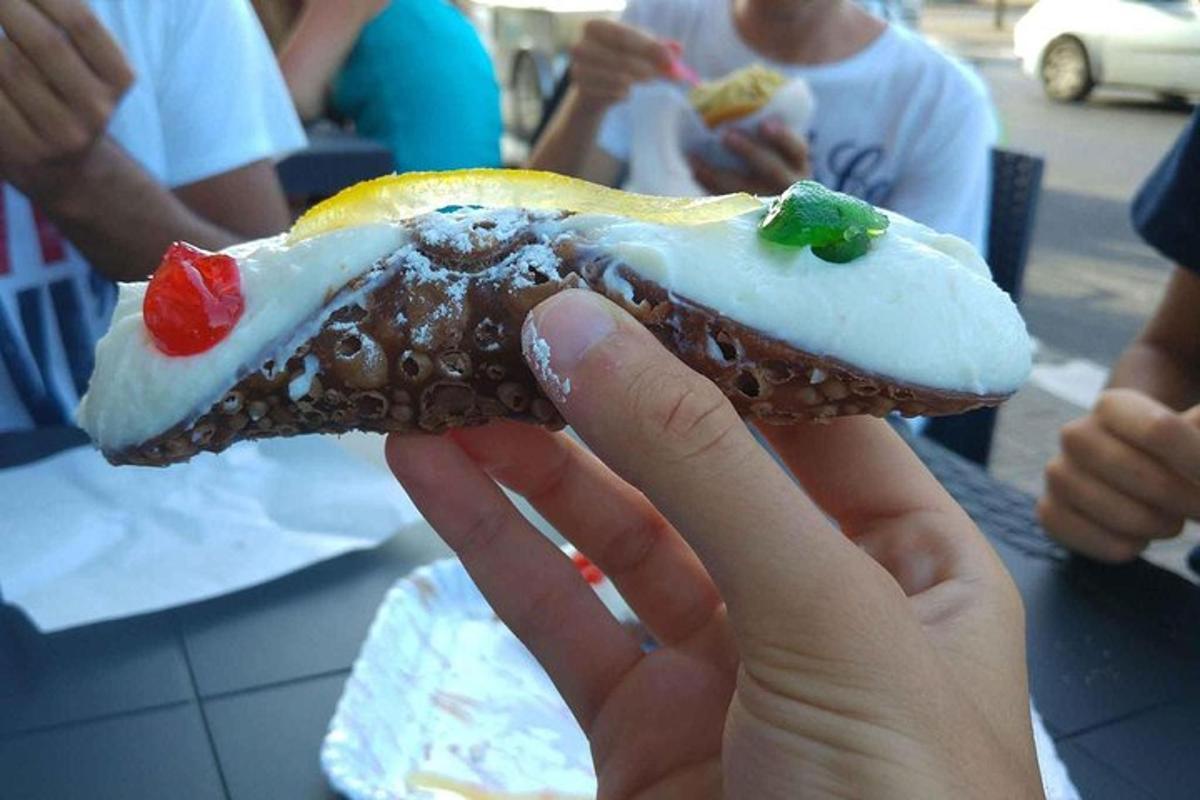 o persoană care ține un hot dog cu toppinguri pe el