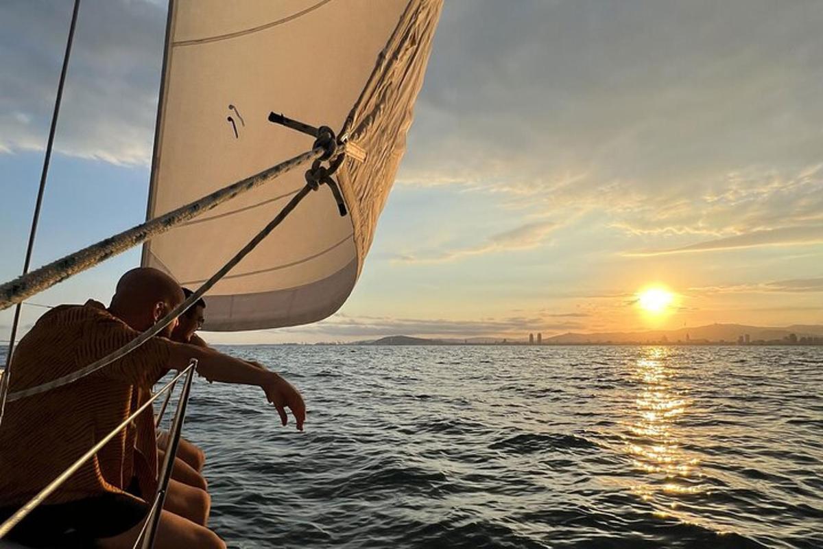 un uomo su una barca a vela nell'oceano al tramonto