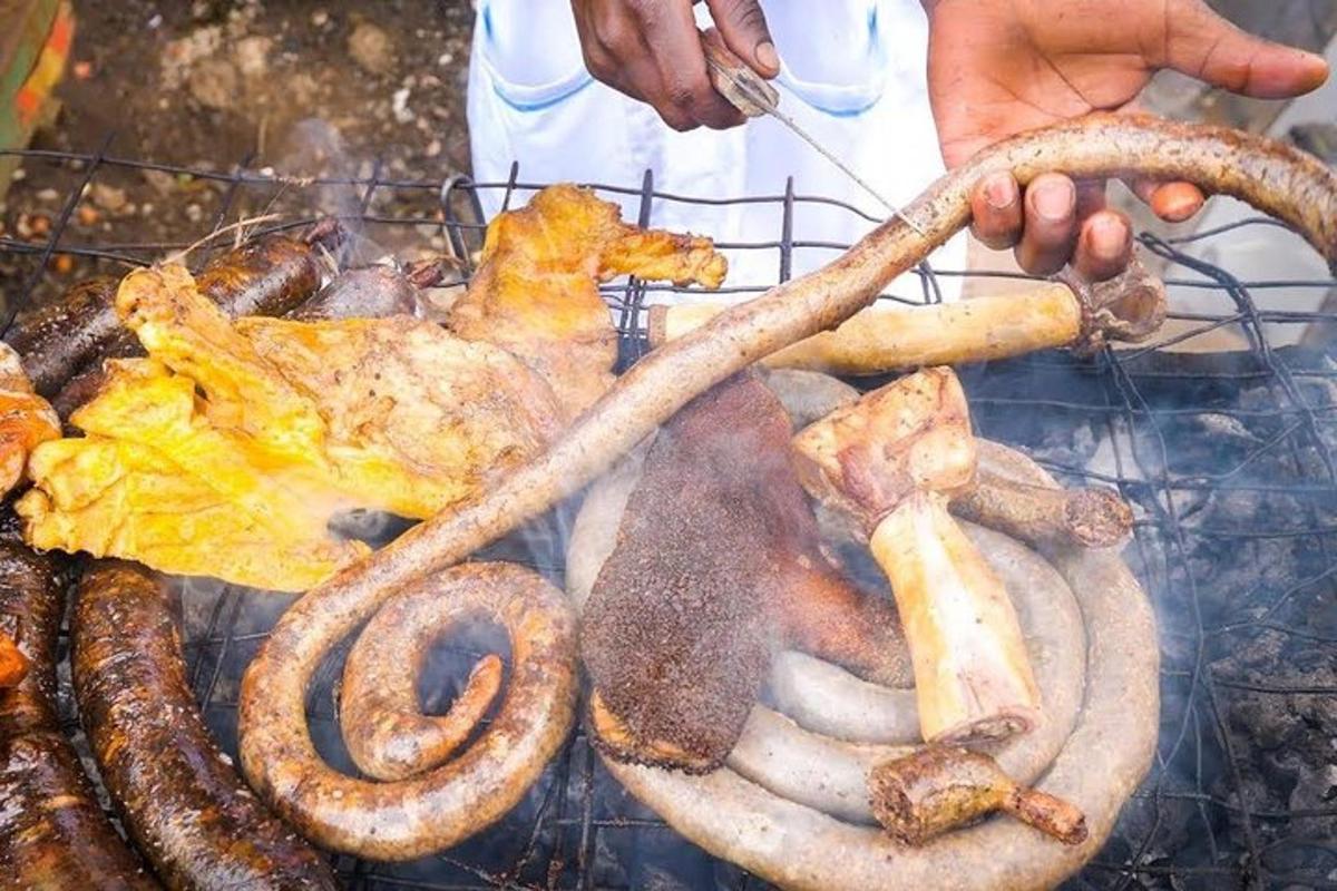 seseorang memasak daging dan sosis di atas panggangan