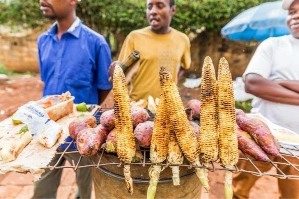 sekelompok pria berdiri di samping meja berisi jagung