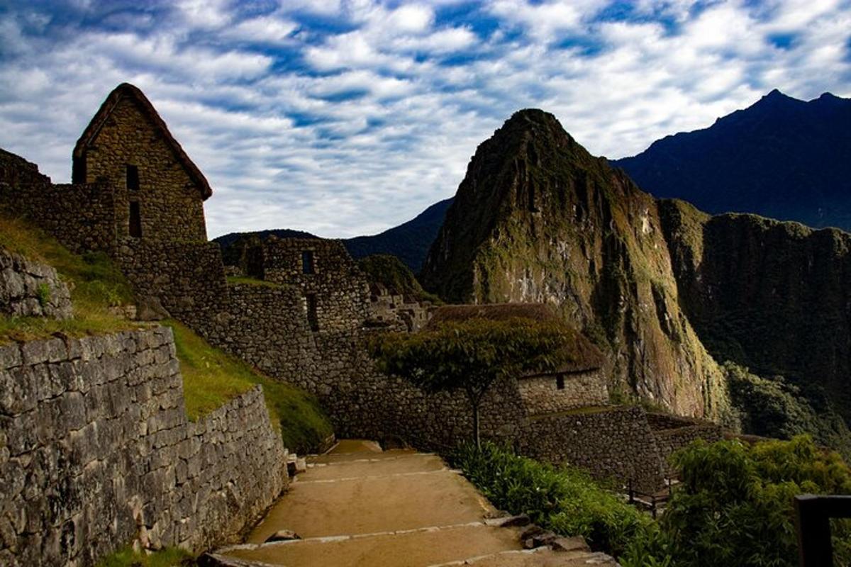 a stone path leading up to a mountain with a building