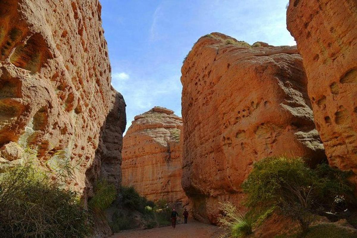 a group of people walking through a slot canyon