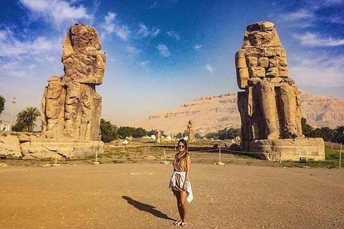 uma mulher em pé em frente a uma estátua de pedra