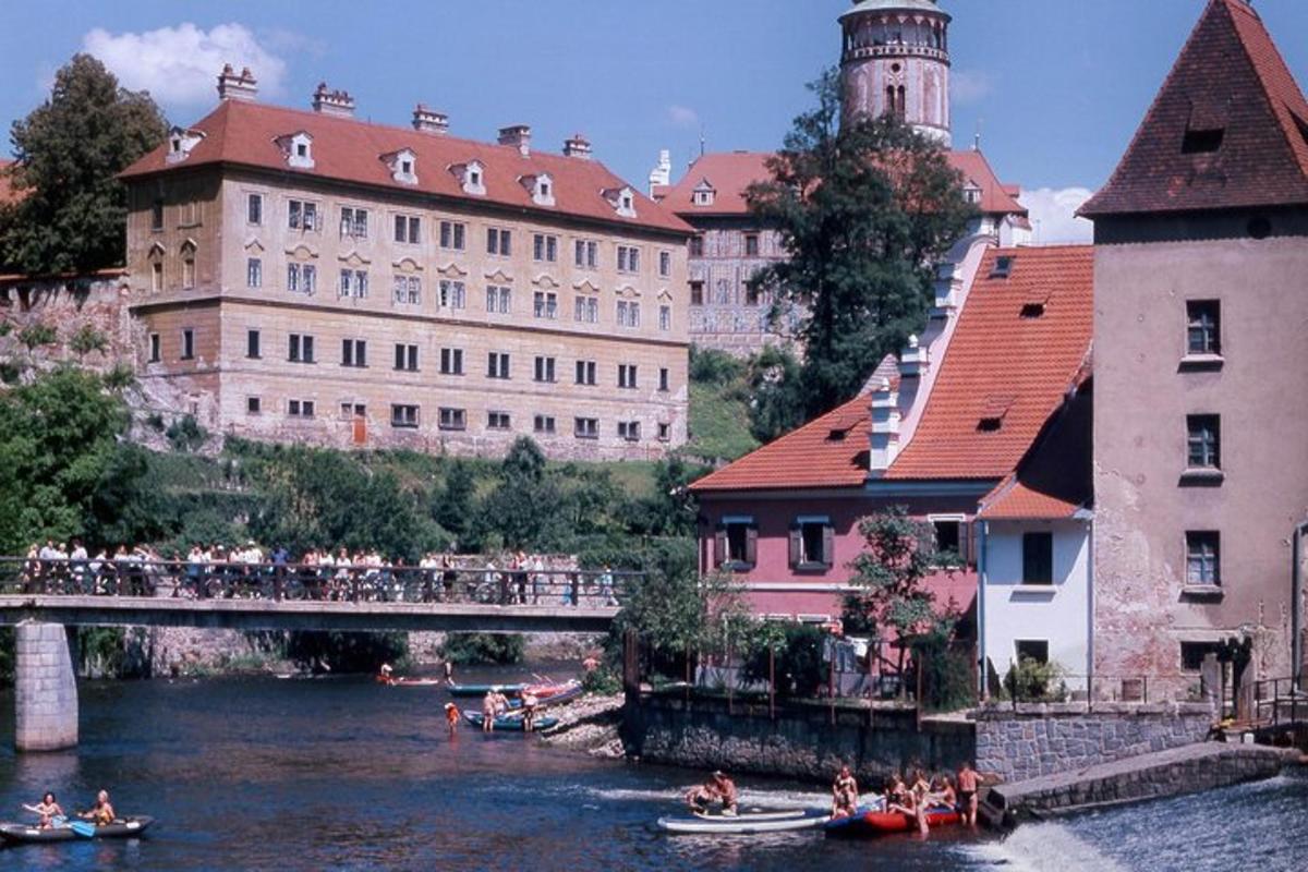 eine Gruppe von Menschen in Booten auf einem Fluss mit Gebäuden
