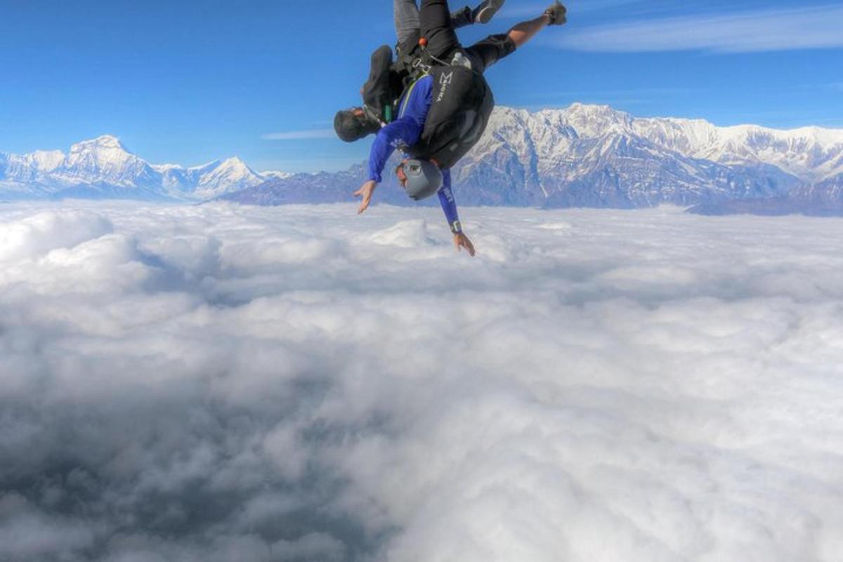 a person is upside down in the sky above the clouds
