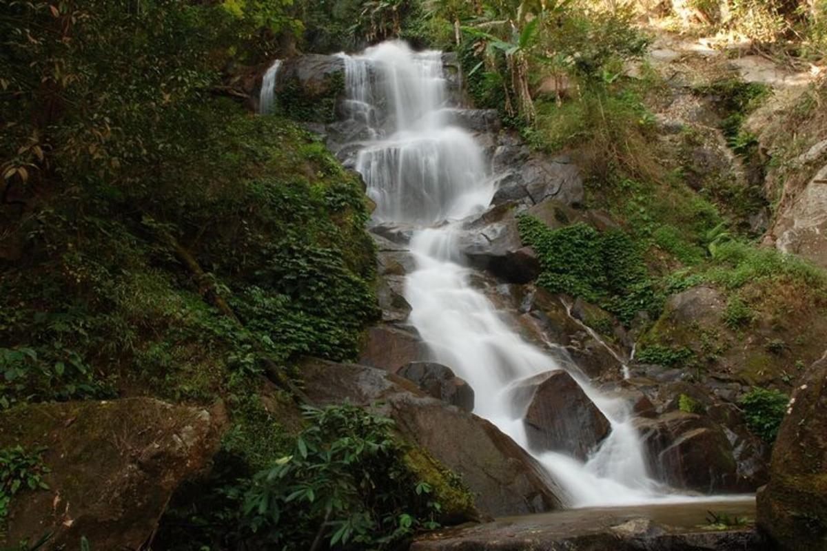 a waterfall on the side of a hill with rocks