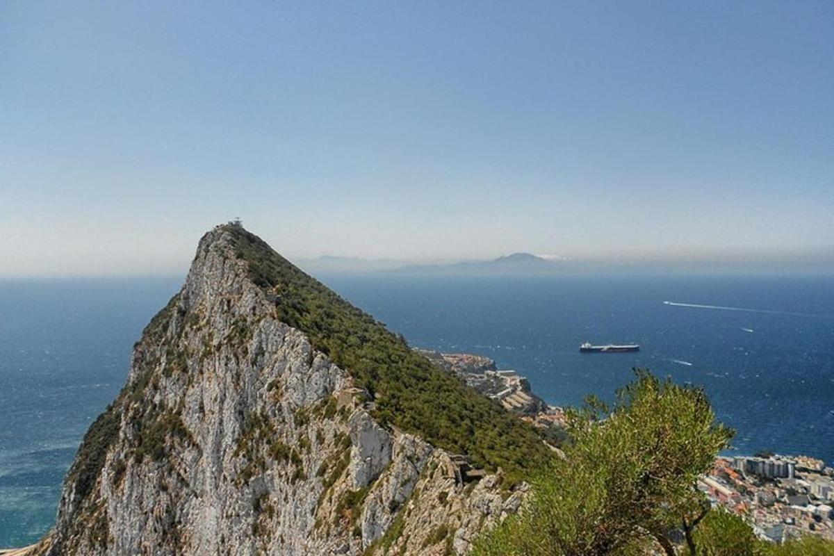uma montanha com vista para o oceano e um barco
