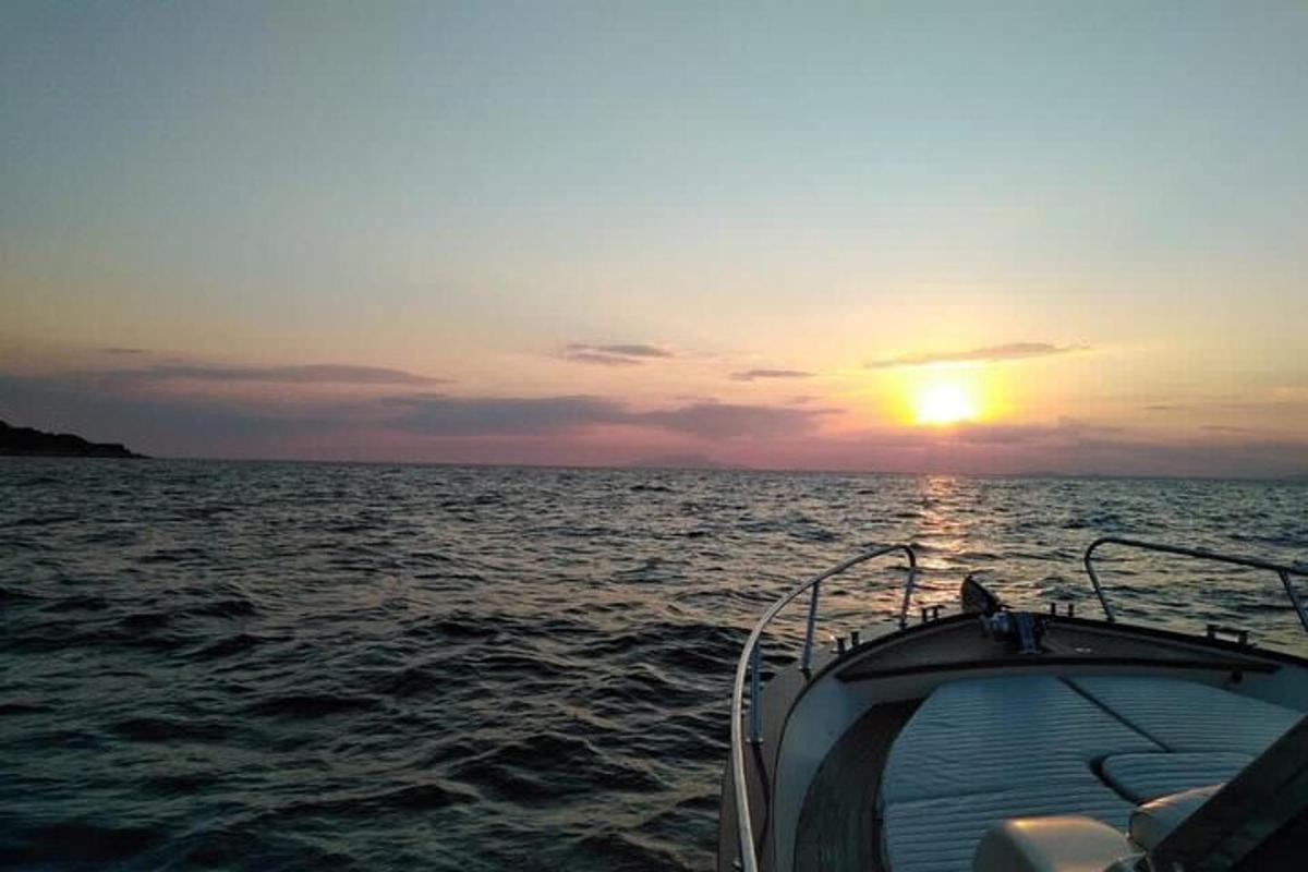 μια βάρκα στον ωκεανό με το ηλιοβασίλεμα στο φόντο