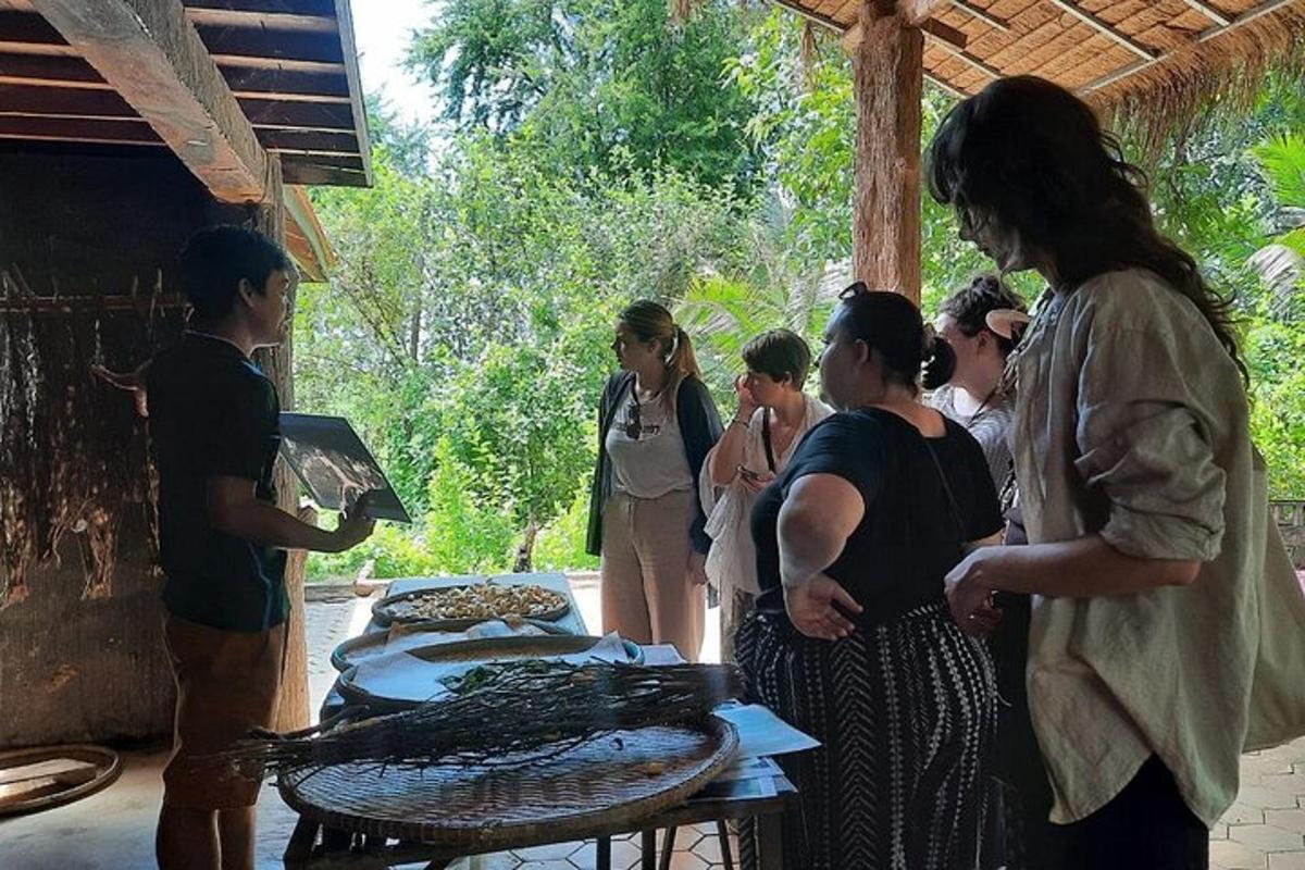 μια ομάδα ανθρώπων που στέκονται γύρω από μια σχάρα με φαγητό