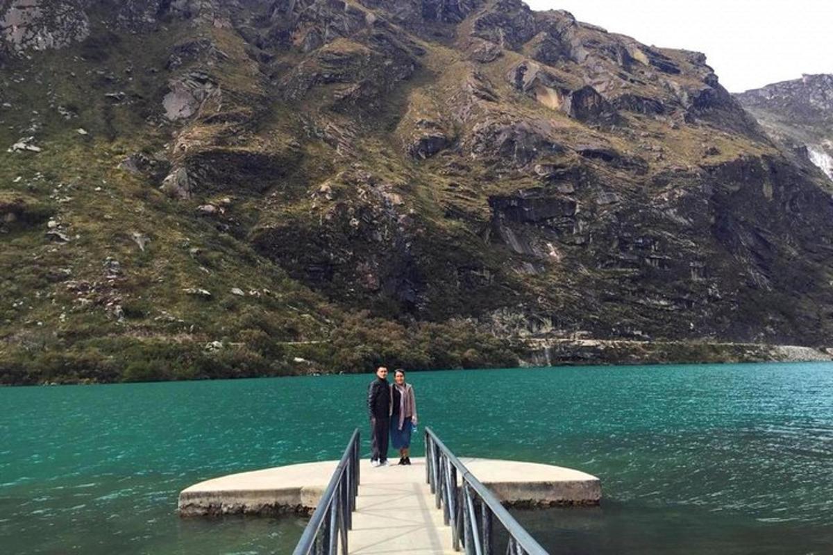 two people standing on a bridge over a body of water