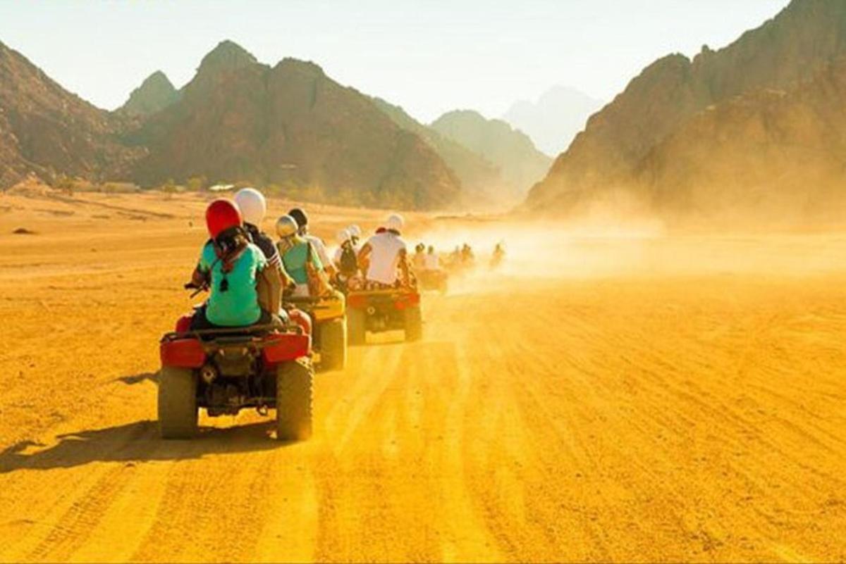 un grup de persones que condueixen motocicletes per un camí de terra
