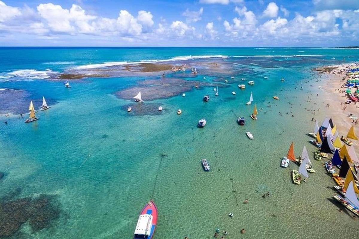 an aerial view of a beach with boats in the water