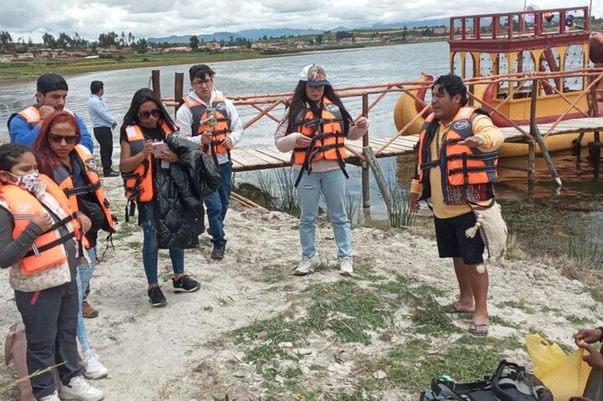 un gruppo di persone che indossano giubbotti di salvataggio in piedi accanto all'acqua