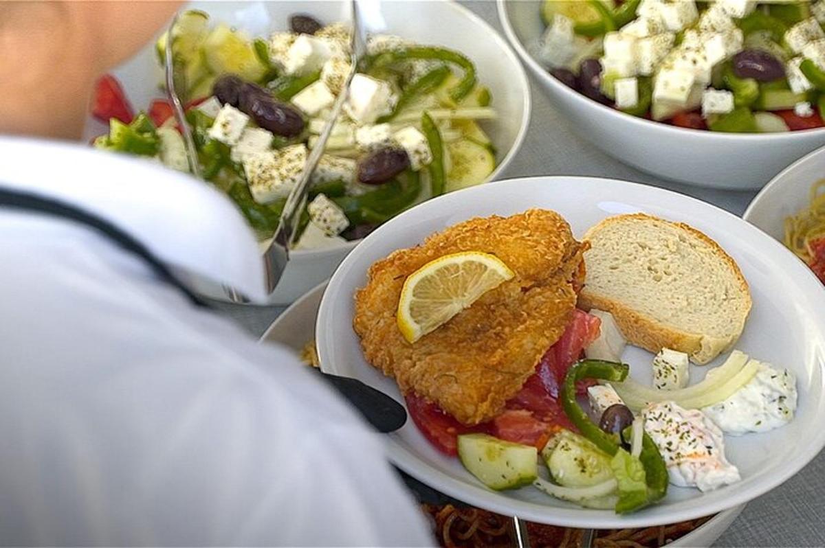 Una mesa con un plato de comida y una ensalada.