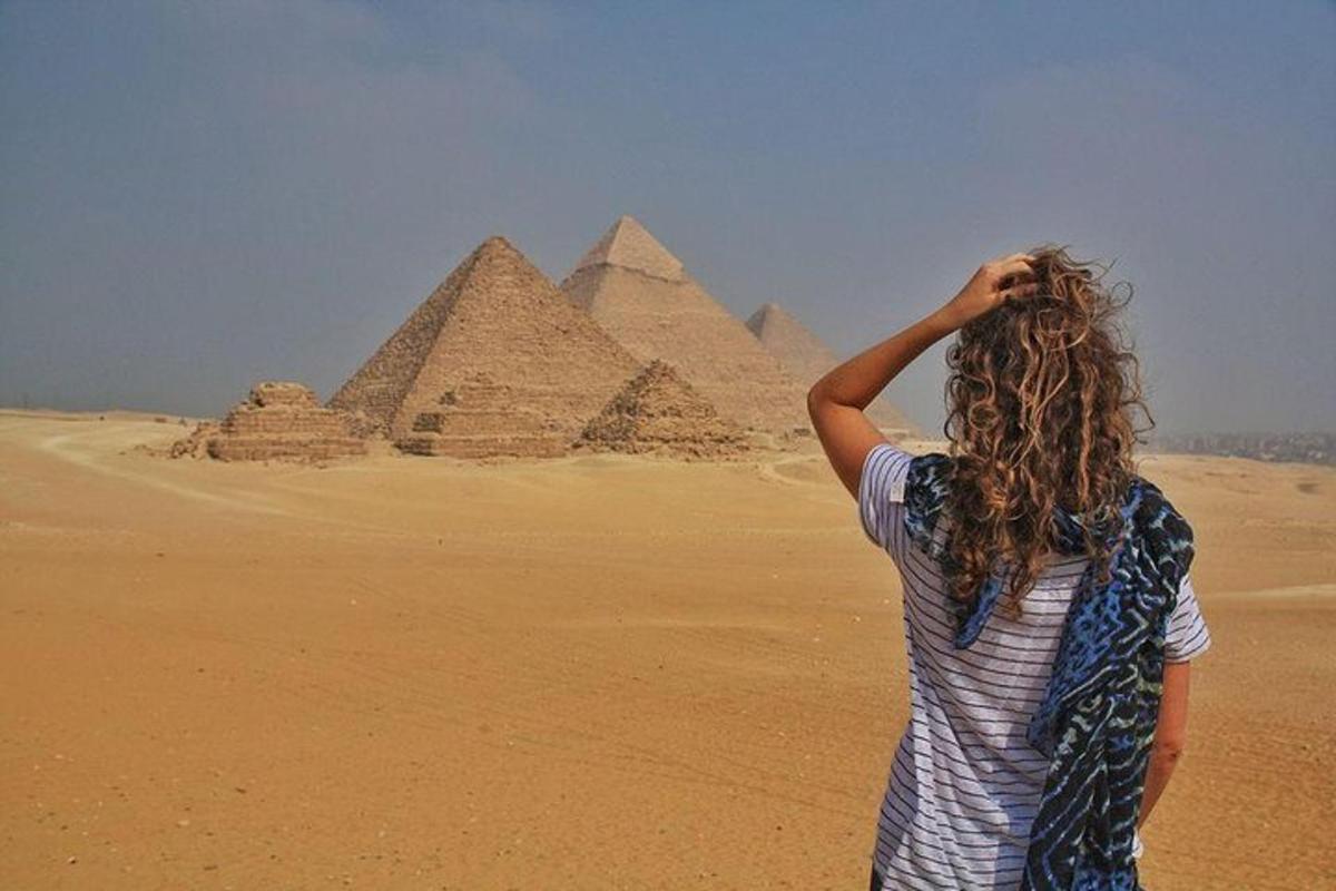 uma mulher em pé em frente às pirâmides
