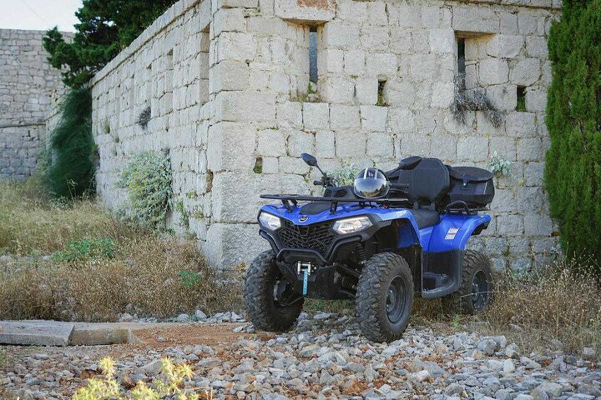 Ένα μπλε ATV παρκαρισμένο μπροστά σε έναν πέτρινο τοίχο