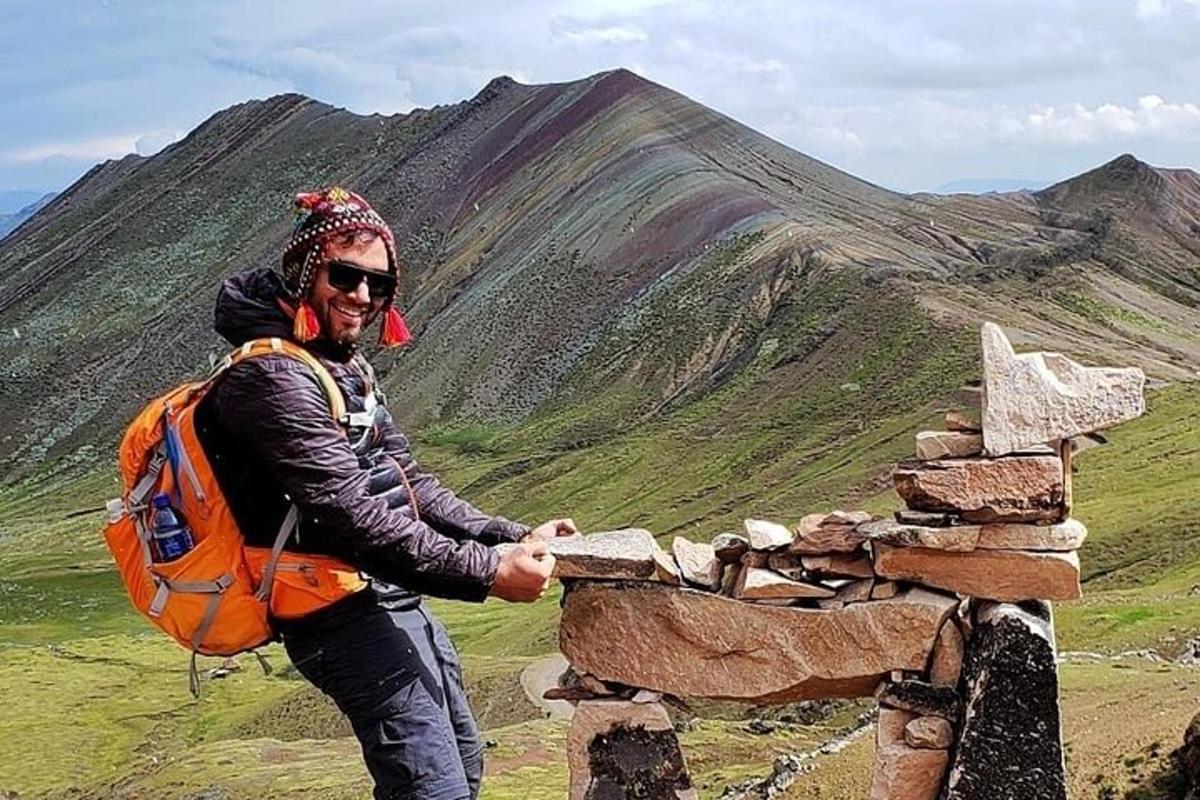 un uomo con uno zaino in piedi sulla cima di una montagna