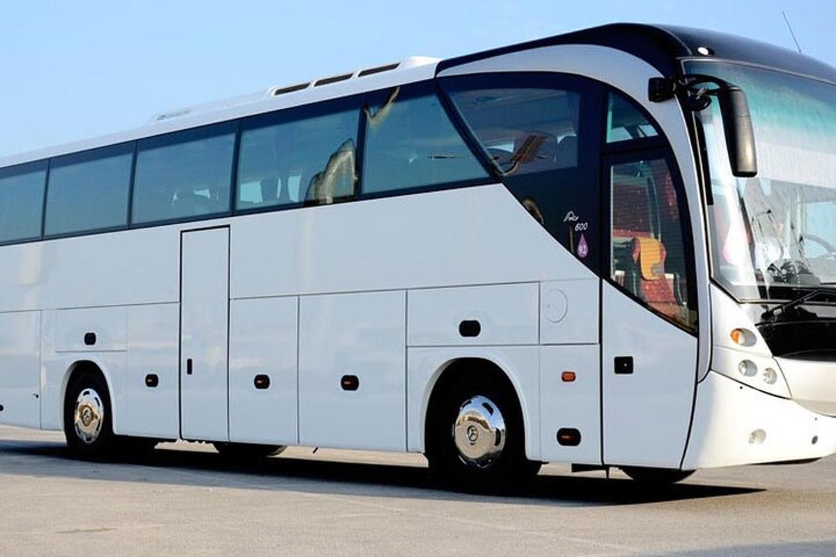 biely autobus zaparkovaný na parkovisku