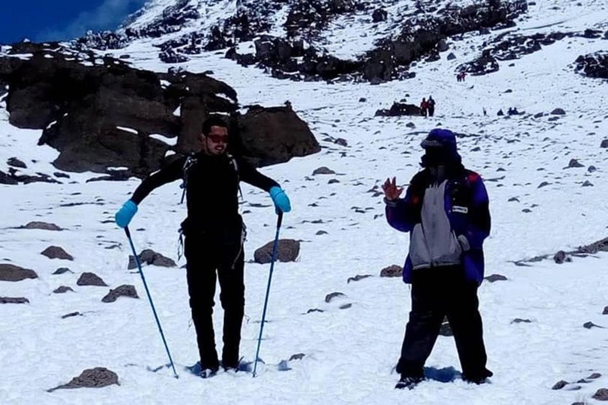 Δύο άνδρες στέκονται στην κορυφή ενός χιονισμένου βουνού