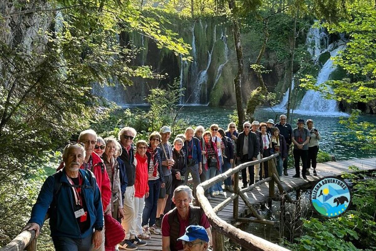 skupina lidí stojící na mostě před vodopádem
