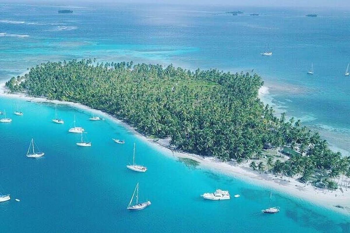 sebuah pulau dengan sekelompok perahu di air