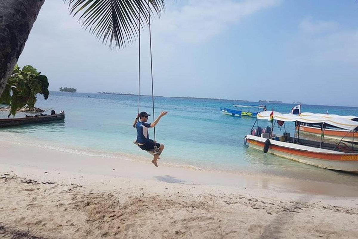 isang taong umuugoy sa isang lubid na indayan sa dalampasigan