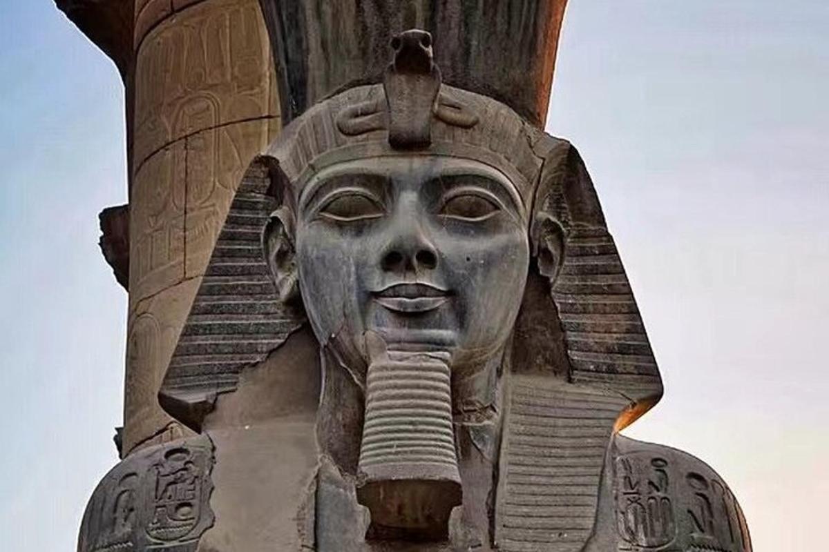 a statue of a head on the side of a building