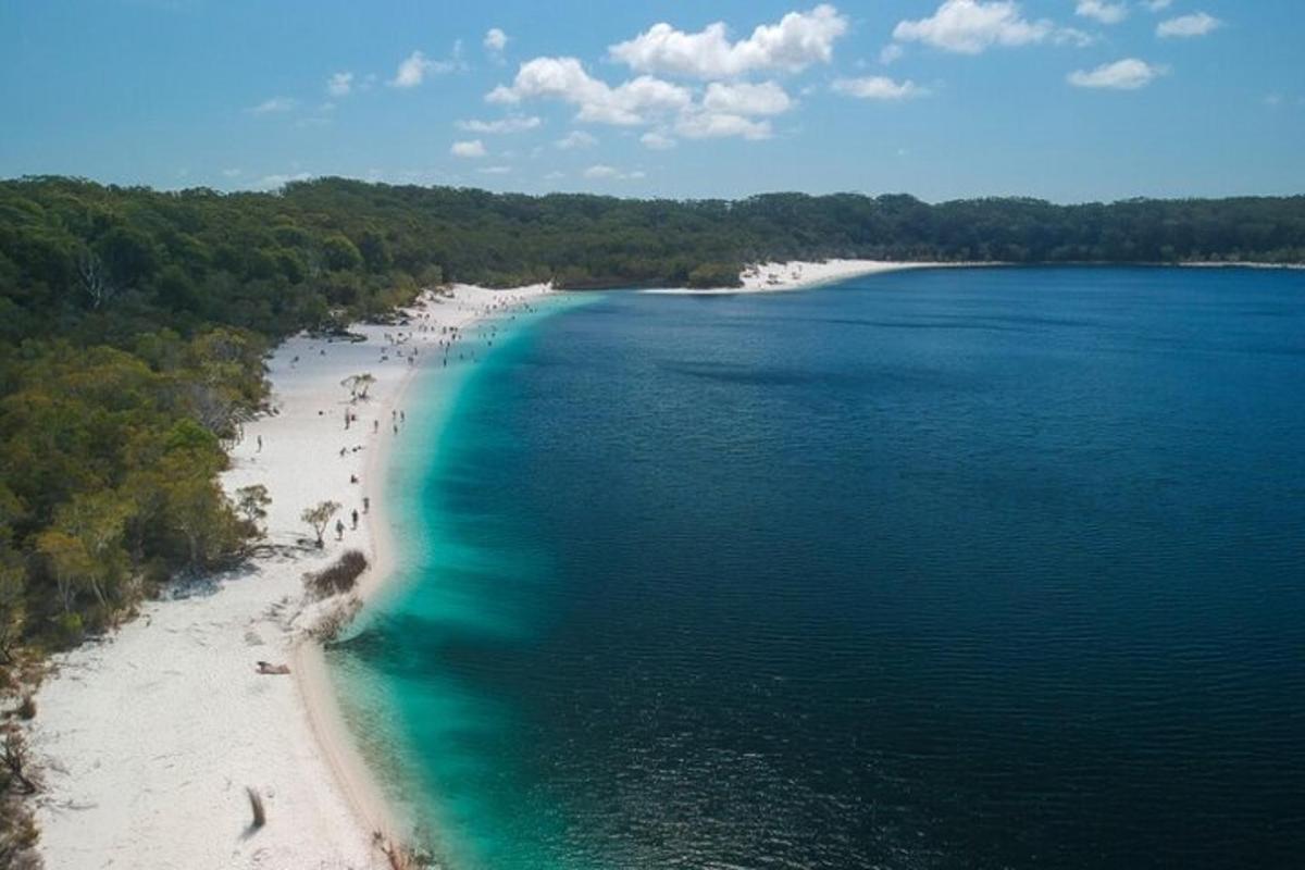 egy légi felvétel egy strandról, ahol emberek vannak a vízben