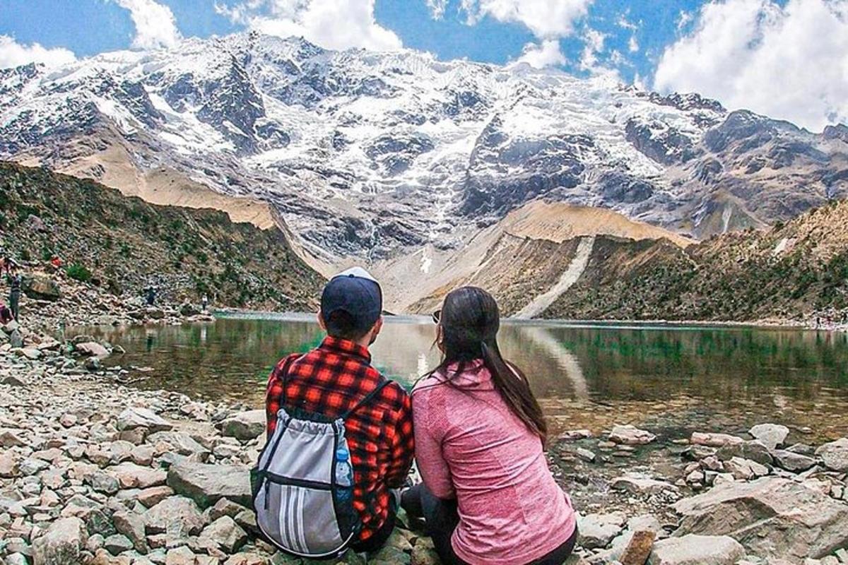 un uomo e una donna seduti sulle rocce che guardano una montagna