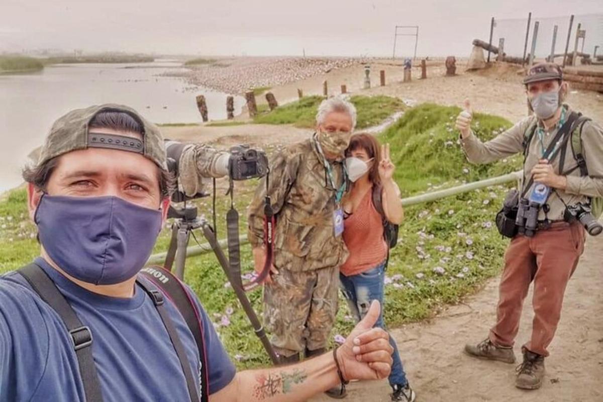 Un grupo de personas de pie junto a una cámara.