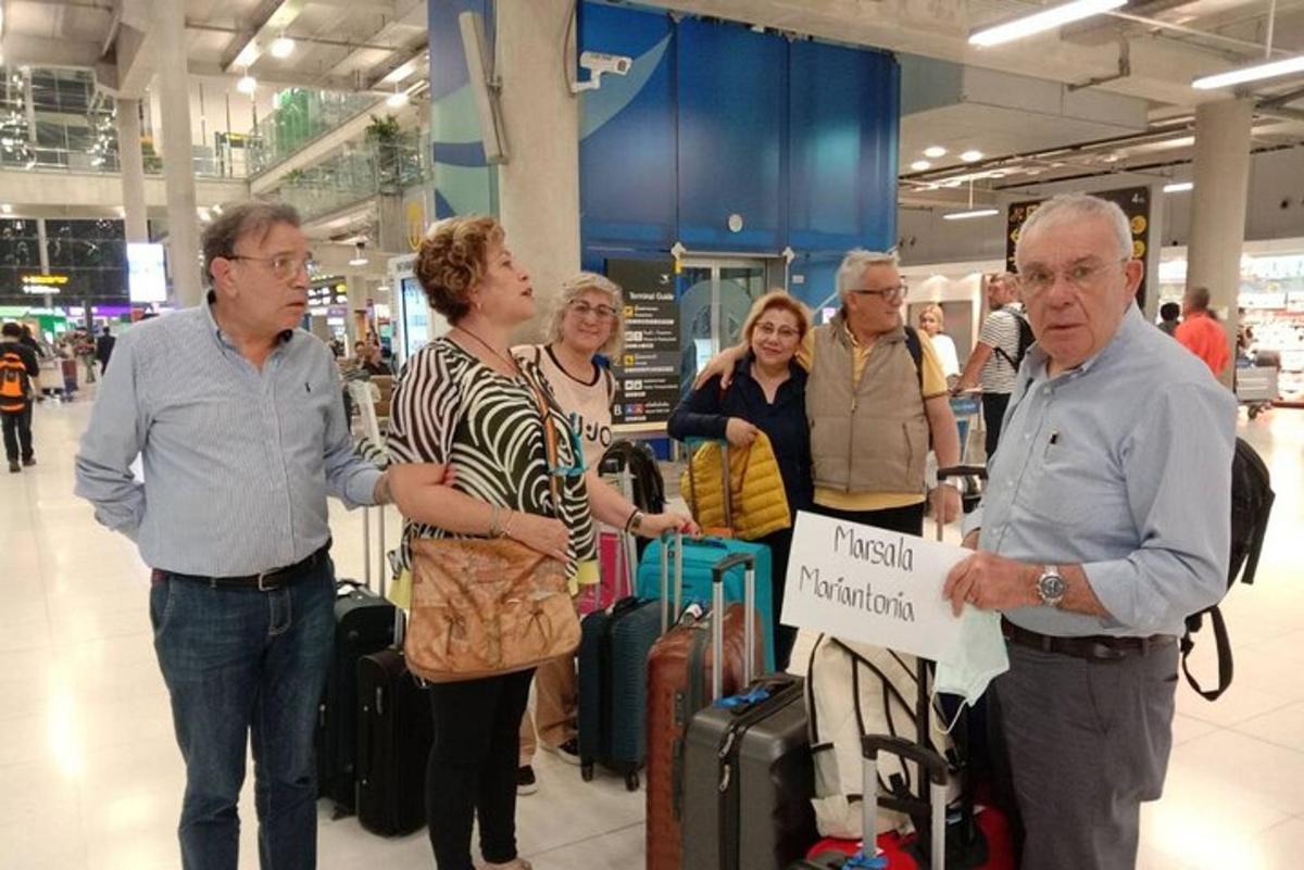 skupina lidí stojících na letišti se zavazadly