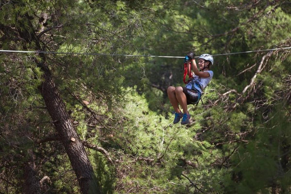 osoba na zip line ve stromech