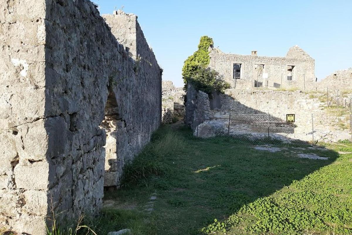 stará kamenná budova s travnatým polem vedle ní