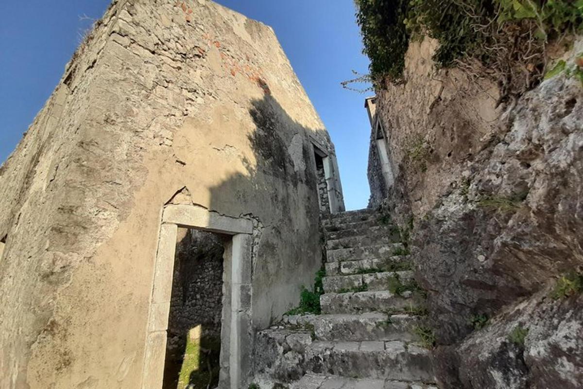 un vecchio edificio in pietra con scale e una porta