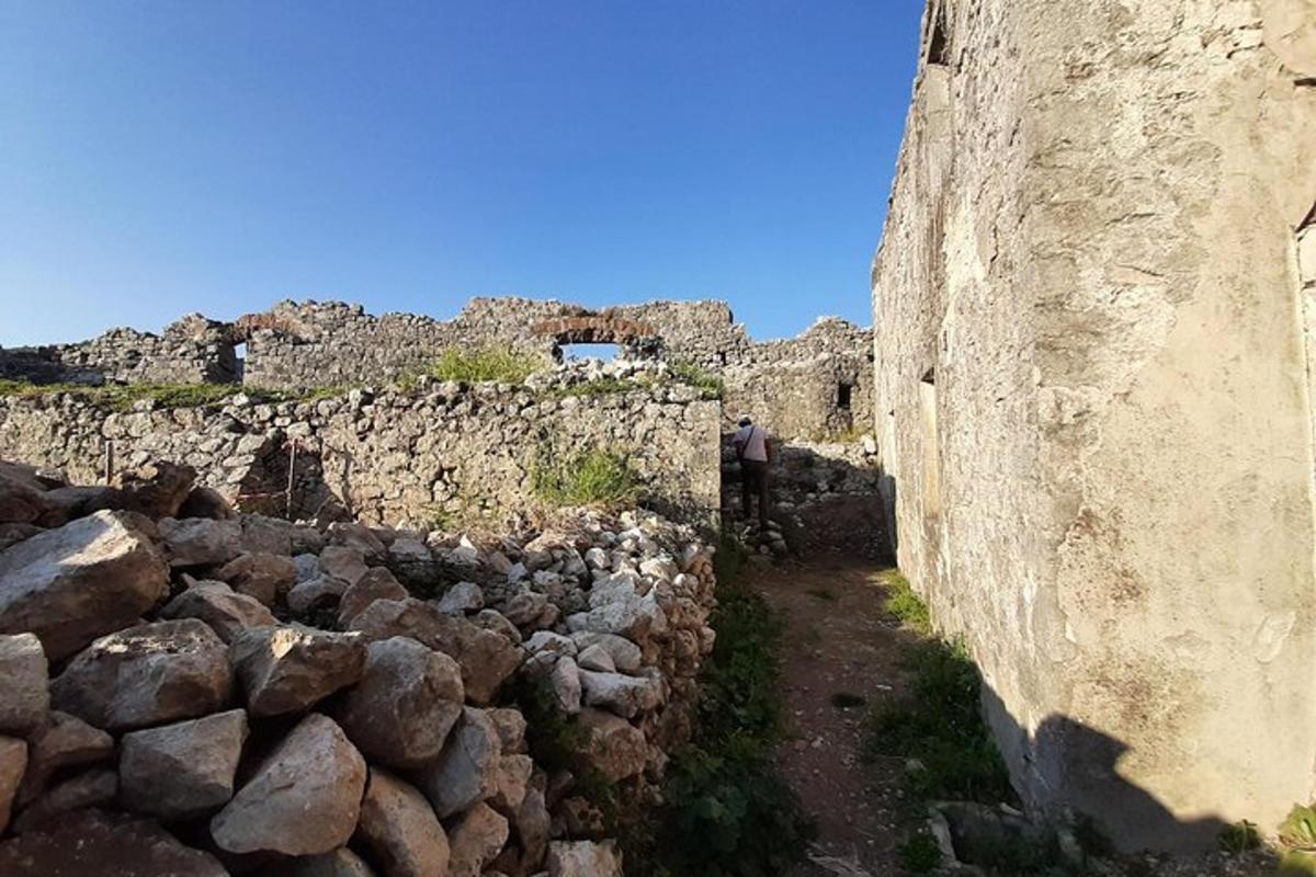 una persona in piedi accanto a un muro di pietra