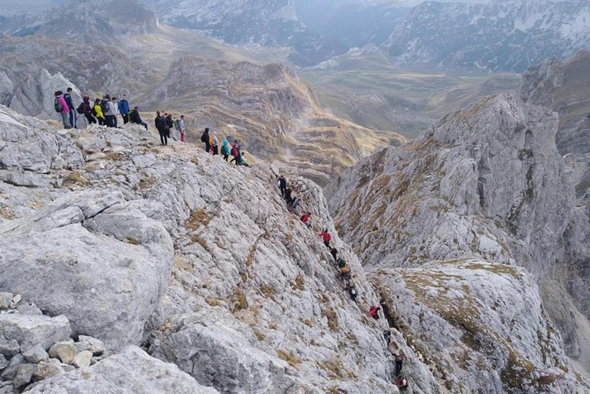 hópur fólks sem stendur uppi á fjallstindi