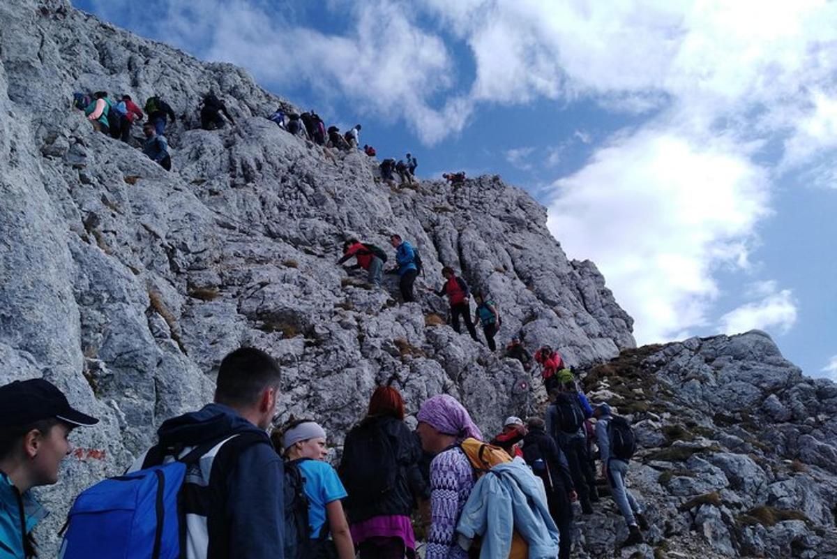 grupp inimesi, kes kõnnivad mööda kaljust mäge üles