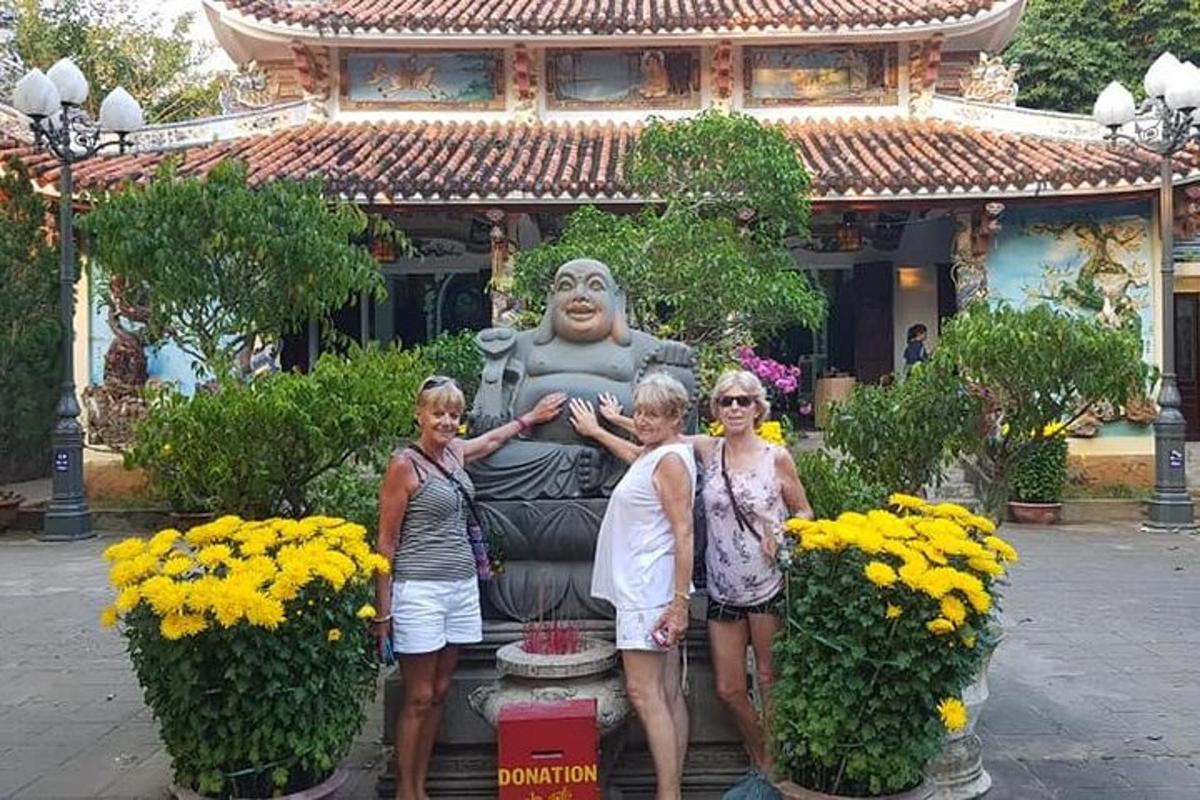 tres dones dempeus al costat d'una estàtua davant d'un edifici