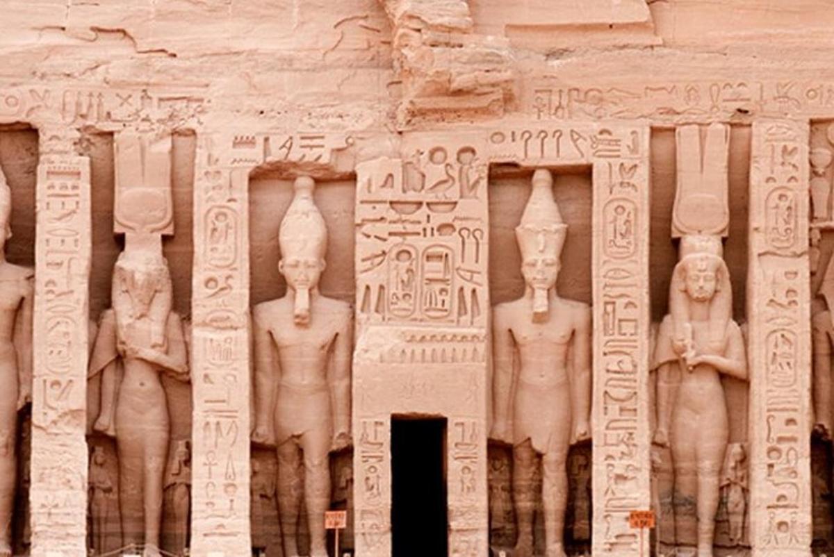 un muro di pietra con statue di uomini su di esso