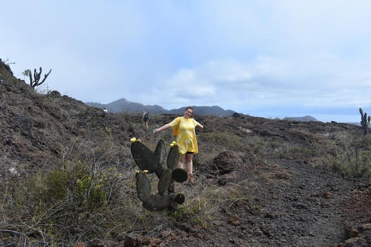 a woman in a yellow dress standing next to a cactus