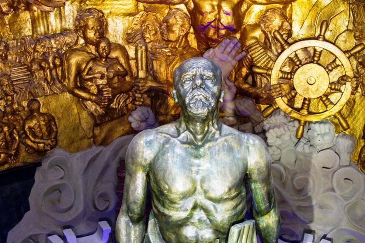a statue of a man in front of a clock