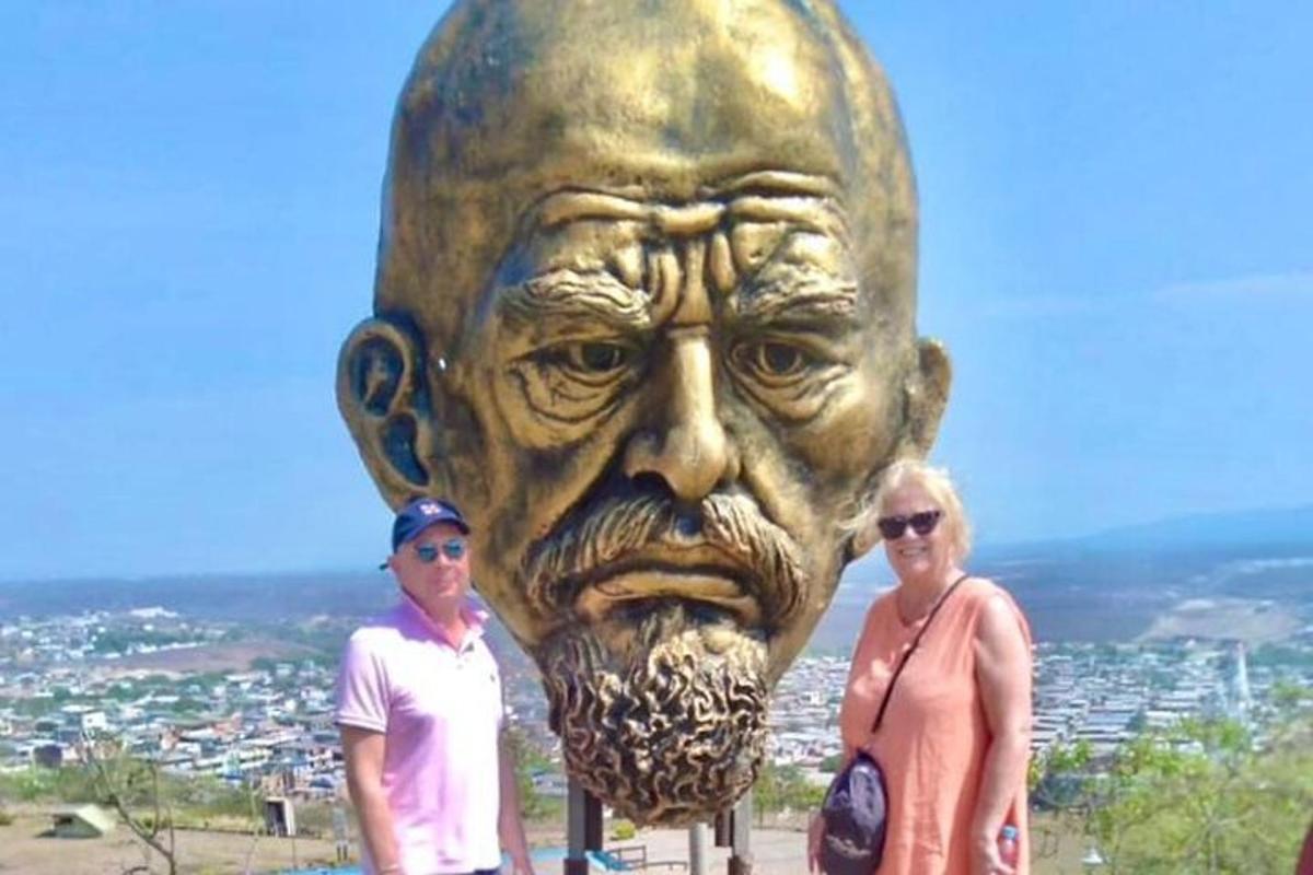 two people standing in front of a large statue