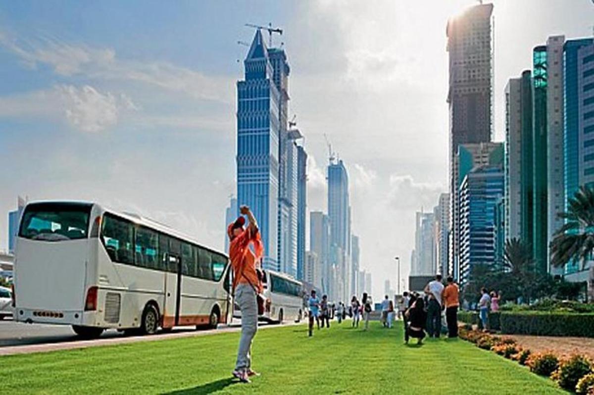 a person standing in a field in front of a bus