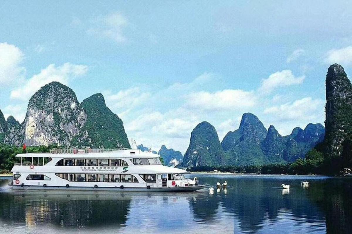 a boat on the water in front of limestone cliffs
