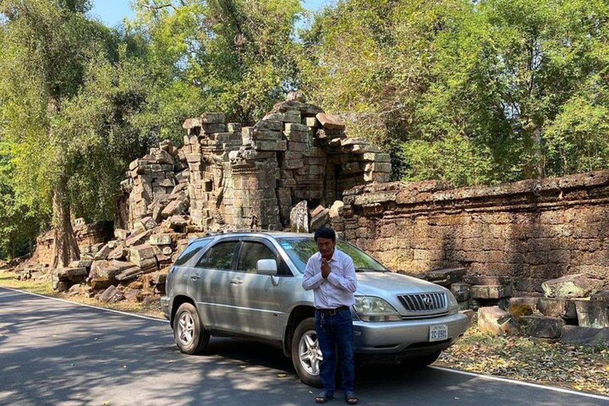 seorang lelaki berdiri di hadapan kereta di jalan
